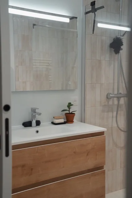 Meuble vasque suspendu en bois à côté de la paroi de douche